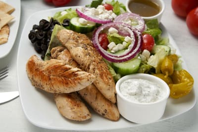 A chicken souvlaki salad with grilled chicken, feta and tzatziki